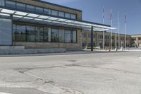 the side of the building features an enclosed glass wall and columns, along with some flags