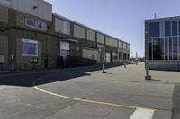 an image of a large brick building in a parking lot and walkway area outside of it