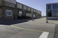 an image of a large brick building in a parking lot and walkway area outside of it