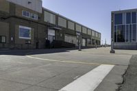 an image of a large brick building in a parking lot and walkway area outside of it