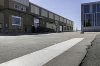 an image of a large brick building in a parking lot and walkway area outside of it