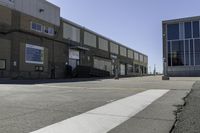 an image of a large brick building in a parking lot and walkway area outside of it