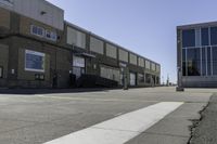 an image of a large brick building in a parking lot and walkway area outside of it