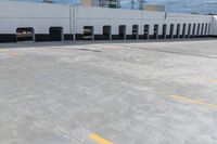 an empty lot with parked cars on it with no people in sight to the pavement