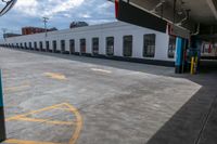 a bus is parked on the side of a long building while waiting for passengers to board