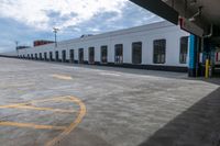 a bus is parked on the side of a long building while waiting for passengers to board