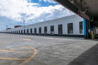 a bus is parked on the side of a long building while waiting for passengers to board