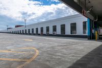 a bus is parked on the side of a long building while waiting for passengers to board