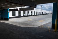 an open parking garage area for parked cars and a blue sky with clouds in the background