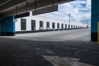 an open parking garage area for parked cars and a blue sky with clouds in the background