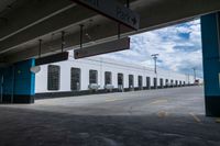 an open parking garage area for parked cars and a blue sky with clouds in the background