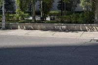 a car driving down an empty street lined with tall buildings and trees in the background