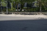 a car driving down an empty street lined with tall buildings and trees in the background