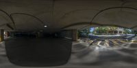 a 360 - lens photo shows inside an empty parking lot near a building that has arches