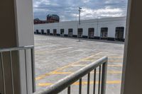 an open door with an empty parking lot and clouds in the background of a building