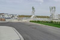 the paved road is empty of cars on either side of the park and along the water