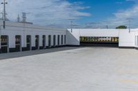 a building with the roof open and lots of empty parking space near by them on the side