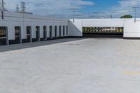 a building with the roof open and lots of empty parking space near by them on the side