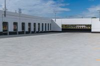 a building with the roof open and lots of empty parking space near by them on the side