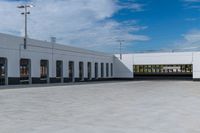 a building with the roof open and lots of empty parking space near by them on the side