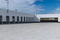 a building with the roof open and lots of empty parking space near by them on the side