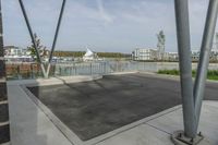 a parking lot in the foreground is made up of two metal poles with a square structure underneath it