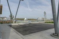 a parking lot in the foreground is made up of two metal poles with a square structure underneath it