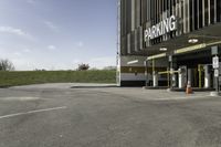 a parking garage with no one in it at the entrance to the building and on the sidewalk