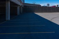 a view of a car parking lot and roller coaster in the background in an urban setting