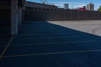 a view of a car parking lot and roller coaster in the background in an urban setting