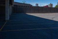 a view of a car parking lot and roller coaster in the background in an urban setting