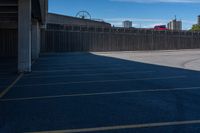 a view of a car parking lot and roller coaster in the background in an urban setting