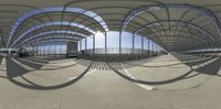 large curved poles standing in a covered area near an airport with a few people on them