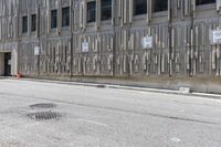 the side of an office building with a few signs on it and concrete around a road