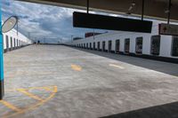 the empty parking lot with a white building on top of it and a yellow doted logo