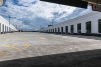 the empty parking lot with a white building on top of it and a yellow doted logo