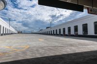 the empty parking lot with a white building on top of it and a yellow doted logo