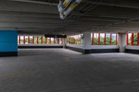 an empty parking garage that has red and white walls and large windows in it with a blue door