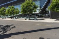 an industrial building with a curved walkway between trees and a sidewalk in front of it