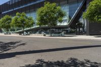 an industrial building with a curved walkway between trees and a sidewalk in front of it