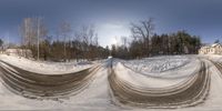 a large pile of dirt covering snow in an open area with trees in the background