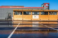 a mcdonalds sitting next to a parking lot under a cloudy blue sky above it