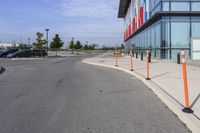 the outside sidewalk of a building with multiple parking spots and parking meter stands along both sides