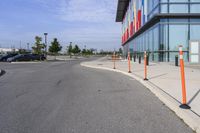 the outside sidewalk of a building with multiple parking spots and parking meter stands along both sides