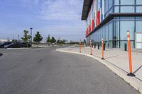 the outside sidewalk of a building with multiple parking spots and parking meter stands along both sides