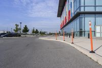 the outside sidewalk of a building with multiple parking spots and parking meter stands along both sides