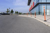 the outside sidewalk of a building with multiple parking spots and parking meter stands along both sides