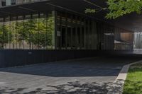 a modern entrance to an office building with concrete and glass walls, as well as the door that leads into the courtyard