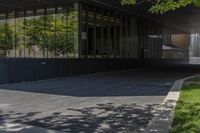 a modern entrance to an office building with concrete and glass walls, as well as the door that leads into the courtyard