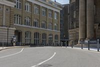 a city street with buildings and pedestrians walking around the curbs down the road next to each other